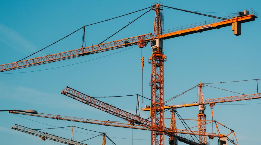 several cranes in front of the sky