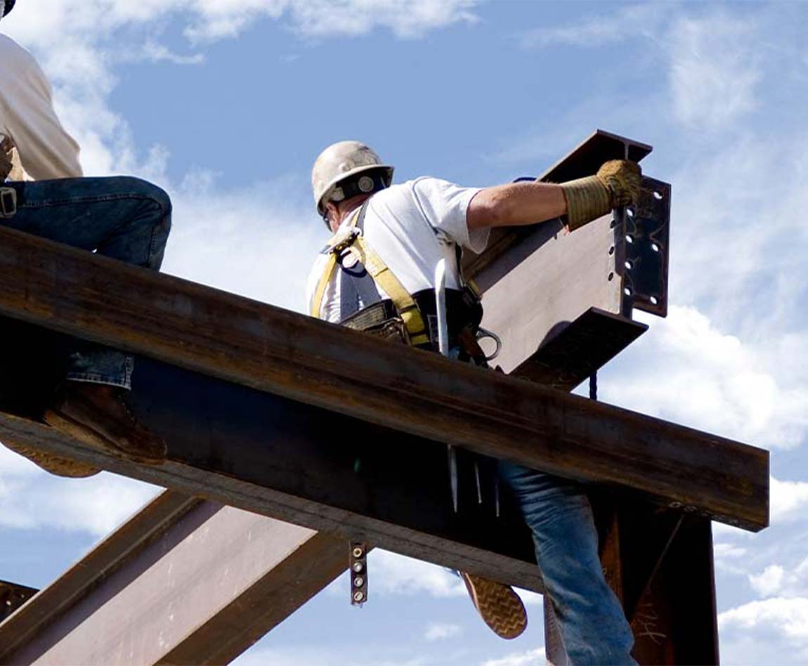 Deux ferronniers au sommet du squelette d'un bâtiment moderne